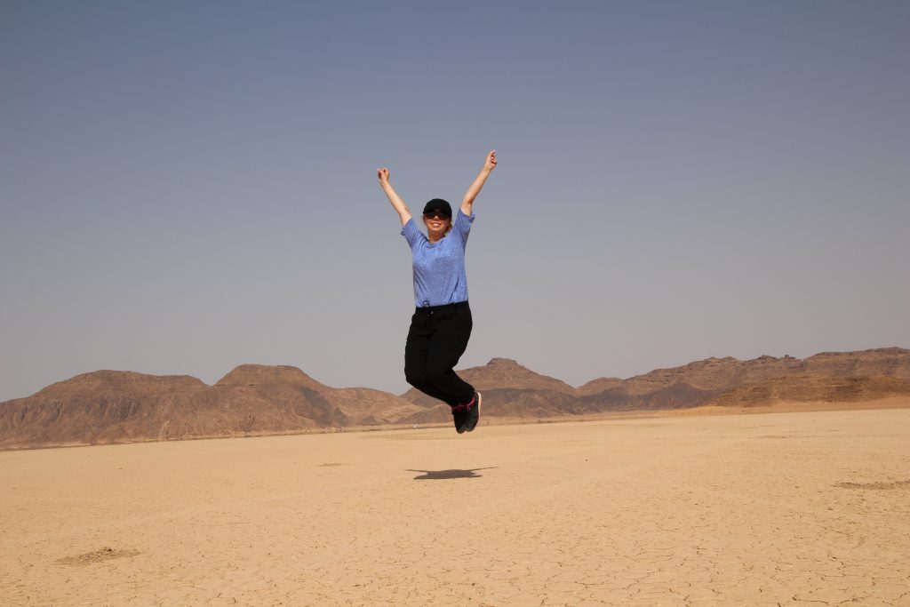 An image of a jumping woman somewhere in Wadi Rum, Jordan.